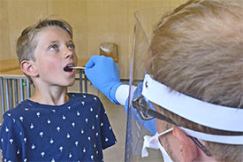  Münchner Virenwächter-Studie: Ein Arzt führt bei einem Grundschüler einen Mund-Abstrich durch.  ©