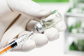Eine medizinische Fachkraft zieht Spritze mit Impfstoff auf.