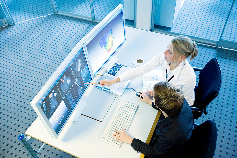 Zwei Wissenschaftlerinnen diskutieren medizinische Aufnahmen am Computerbildschirm.