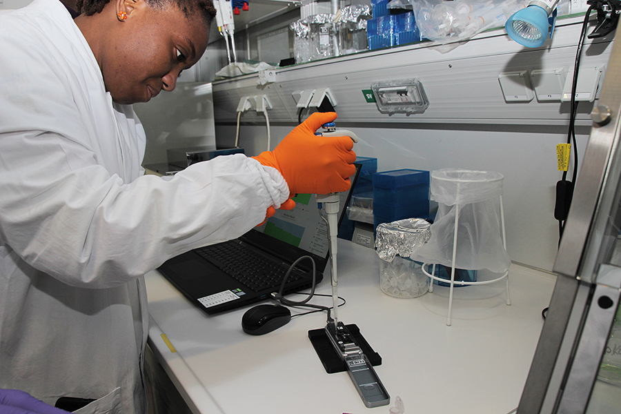 Adja Traore von der Elfenbeinküste trainiert am Robert-Koch-Institut den Umgang mit der mobilen MinION-Technik, mit der SARS-CoV-2 sequenziert wird.