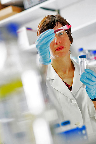 Forscherin im Labor hält Reagenzglas mit Blut