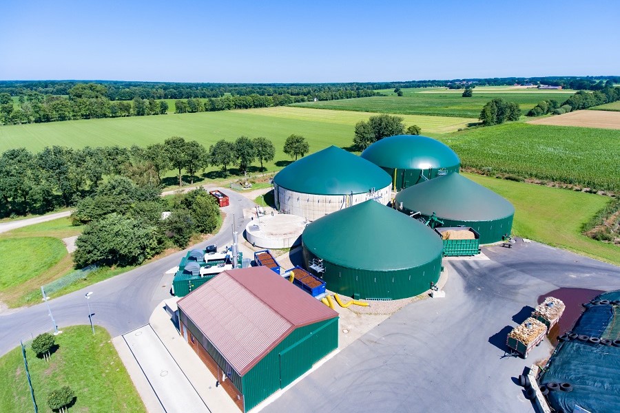 Eine Biogasanlage umgeben von grünen Feldern