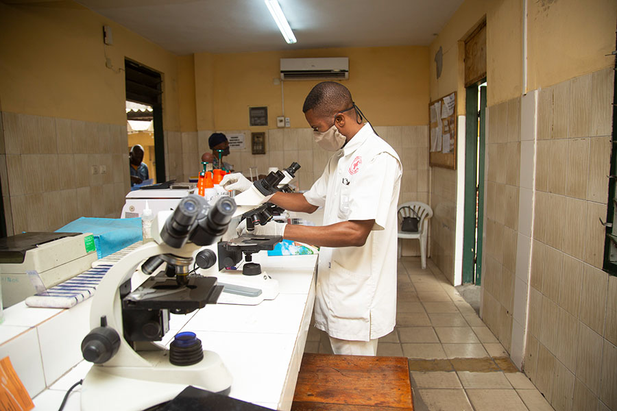 Afrikanischer Laborant in einem Raum mit mehreren Mikroskopen