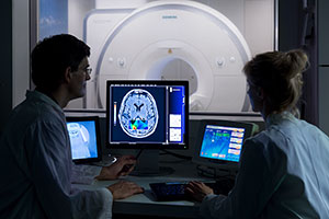Zwei Forscher betrachten MRT-Bild am Computer.