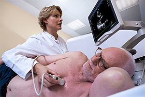 Ärztin untersucht Herz eines Patienten per Ultraschall