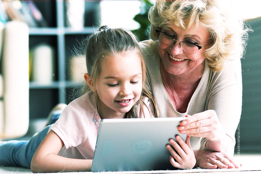 Oma mit Kind schauen auf Tablet