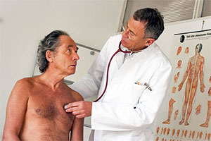 Arzt hört Herz eines Patienten ab mit einem Stethoskop