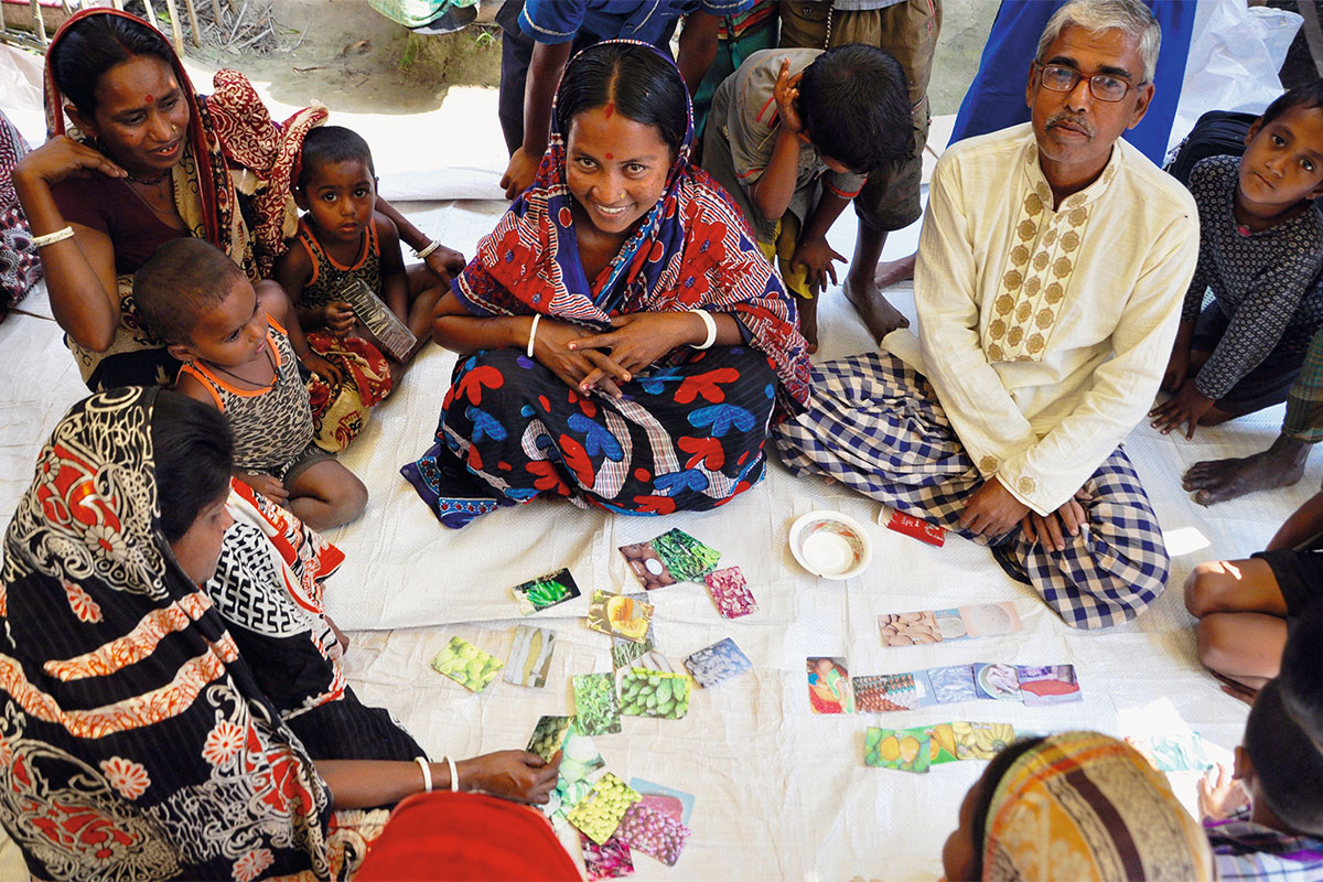 Frauen mit ihren Kindern nehmen an Ernährungsschulung teil.