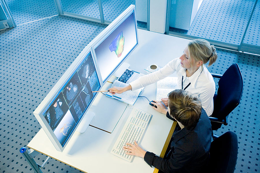 Zwei medizinische Fachangestellte sehen sich digitale Daten an