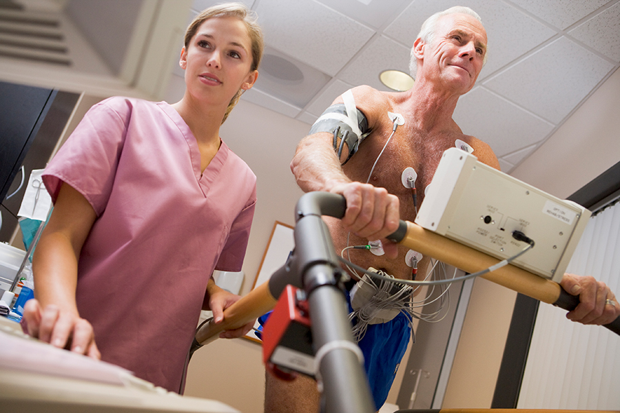 Eine medizinische Fachkraft überwacht einen Patienten beim Belastungs-EKG