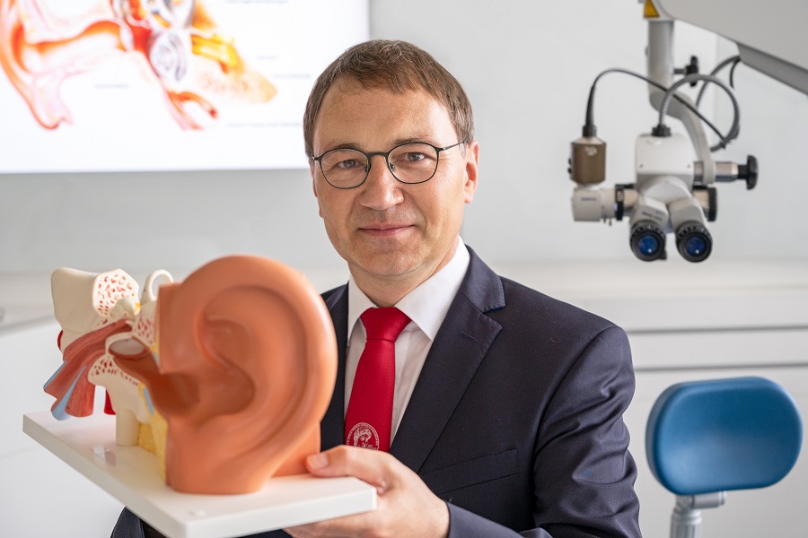 Professor Dr. Stefan Plontke mit einem Modell eines Ohrs in den Händen