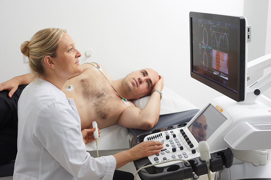 Ärztin untersucht Herz eines Patienten mit Ultraschall