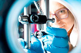 Der feine Flüssigkeitsstrahl, den die Physikerin Rita Graceffa in einer Vakuumkammer justiert, kann Proben wie Viren, Zellen oder Bakterien liefern, so dass sie mit Röntgenlaserblitzen untersucht werden können.