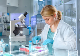 Forscherin untersucht den Inhalt einer Petrischale im Labor
