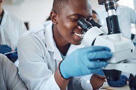 Junger Arzt in Afrika schaut durch ein Mikroskop
