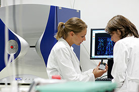 Zwei Wissenschaftlerinnen im Labor betrachten digitales Messgerät
