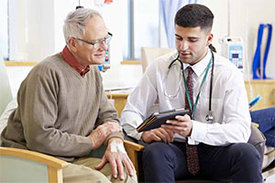 Patient und Arzt schauen auf ein Tablet