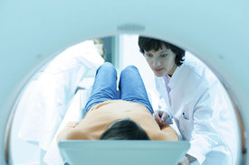 Ärztin nimmt bei einer Patientin eine MRT-Untersuchung vor.