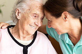 Pflegekraft kümmert sich um Seniorin.