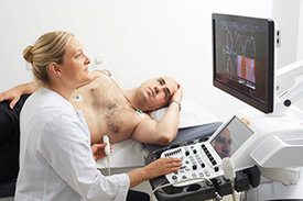 Ärztin untersucht Herz eines Patienten mit Ultraschall