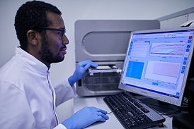 Wissenschaftler schaut auf PCR-Gerät für den Nachweis von Erregern wie SARS-CoV-2 